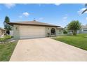 Charming single-story home featuring a lush front lawn and an attached two-car garage at 7022 Kingsway Dr, Port Richey, FL 34668