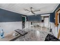 Spacious living room featuring tile floors, ceiling fan and unfinished walls awaiting a personalized design at 814 Florida Ave, Palm Harbor, FL 34683