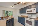 Bright kitchen features tile floors, blue cabinets, and white appliances at 9630 Carlsdale Dr, Riverview, FL 33578