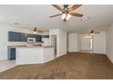 Open-concept living area features neutral paint, ceiling fans, and tile flooring near the kitchen space at 9630 Carlsdale Dr, Riverview, FL 33578