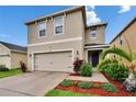 Charming two-story home with a well-maintained lawn and colorful landscaping at 11019 Leland Groves Dr, Riverview, FL 33579