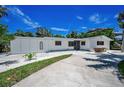 Single story home featuring an expansive driveway and well-maintained landscaping at 112 Peterson Ln, Palm Harbor, FL 34683