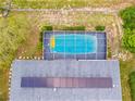 Birds-eye view showcases solar panels, screened-in pool, and backyard, emphasizing privacy at 12546 Brookside St, Spring Hill, FL 34609