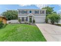 Well-kept two-story home with a green lawn, a two-car garage, and a charming green front door at 1291 Blackrush Dr, Tarpon Springs, FL 34689