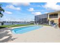 Sparkling pool is surrounded by lush landscaping and a waterfront view, creating a private oasis at 17025 Dolphin Dr, North Redington Beach, FL 33708