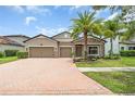Charming home features a brick driveway, a two-car garage, and stone accents on the facade at 1830 Cameron Ct, Trinity, FL 34655