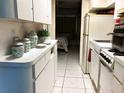 Functional kitchen featuring white cabinets, appliances, and a view into the bedroom at 1865 Mazo Manor # 1, Lutz, FL 33558