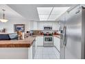 Bright kitchen featuring white cabinetry, stainless steel appliances, and terracotta countertops at 19029 Us Highway 19 N # 8-31, Clearwater, FL 33764