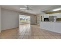 Open concept living room with tile flooring, a ceiling fan, and a view into the sunroom at 1903 Canterbury Ln # B24, Sun City Center, FL 33573