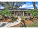 Charming brick home featuring a walkway with a double door entry and lush landscaping at 302 Old Mulrennan Rd, Valrico, FL 33594