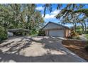 Detached brick garage with covered parking area on a spacious driveway at 302 Old Mulrennan Rd, Valrico, FL 33594