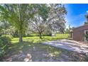 Expansive backyard featuring a brick patio, mature trees, and ample green space at 3125 S Miller Rd, Valrico, FL 33596