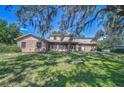 Charming home with a brick exterior, a well-maintained lawn, and mature trees offering shade at 3125 S Miller Rd, Valrico, FL 33596