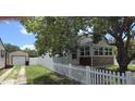 Fenced backyard with lush tree providing shade; detached garage and additional sunroom for extra space at 3131 Melton N St, St Petersburg, FL 33704