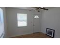 Comfortable living room featuring laminate wood flooring, natural light through a window and door, and a ceiling fan at 3131 Melton N St, St Petersburg, FL 33704