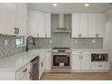 Modern kitchen featuring white cabinets, stainless steel appliances, and a stylish backsplash at 463 85Th Ave, St Pete Beach, FL 33706