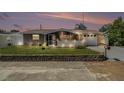 Charming single-story home featuring a screened porch, landscaped yard, and a one-car garage at dusk at 5128 Billings Dr, Holiday, FL 34690