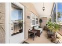 Inviting covered front porch with comfortable seating and a decorative glass front door at 5128 Billings Dr, Holiday, FL 34690