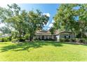 Beautiful single-story home with mature trees shading the lush green lawn, offering curb appeal at 5927 Flatwoods Manor Cir, Lithia, FL 33547