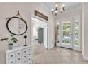 Elegant foyer with tile flooring, a decorative mirror, and a view into the adjacent living spaces at 6207 Bleeker St, Riverview, FL 33578