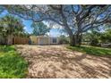 Charming yellow single-story home with a brick driveway and a large shade tree in the front yard at 914 Sandpiper Way S, St Petersburg, FL 33707