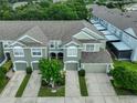 Aerial view of townhome with gray roof, green siding, manicured landscaping, and two-car garages at 10132 Post Harvest Dr, Riverview, FL 33578