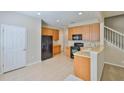 Bright kitchen with wood cabinets, black appliances, and tiled floor at 10132 Post Harvest Dr, Riverview, FL 33578