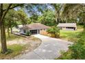 Aerial view of home featuring a circular driveway, fenced yard, well-maintained lawn, and detached outbuilding at 11317 Fort King Rd, Dade City, FL 33525