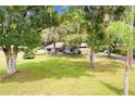 Charming single-story home featuring a brick facade, covered porch, mature landscaping, and a well-manicured lawn at 11317 Fort King Rd, Dade City, FL 33525