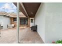 Covered brick patio featuring a seating area, white door and exterior paint at 11317 Fort King Rd, Dade City, FL 33525