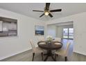Cozy dining area with a modern chandelier, a dark round table set for four, and views into the bright living spaces at 1210 Eastloch Ct, Sun City Center, FL 33573