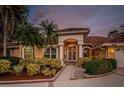 Charming home with mature landscaping, brick accents, and a grand entrance showcasing curb appeal and elegant design at 1303 Forestedge Blvd, Oldsmar, FL 34677