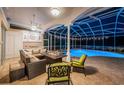 Screened-in lanai with covered seating area with fireplace, outdoor kitchen, and a sparkling pool for relaxation at 1303 Forestedge Blvd, Oldsmar, FL 34677