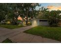 Charming single-story home at dusk with a well-maintained lawn and mature trees providing shade at 1309 11Th W Ave, Palmetto, FL 34221