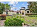 Charming home featuring unique tower, arched windows, and well-manicured landscaping at 13503 Gopher Pond Ct, Hudson, FL 34669