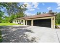 Spacious multi-car garage with modern doors, ample parking, and lush greenery nearby at 13503 Gopher Pond Ct, Hudson, FL 34669