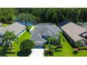 Scenic aerial view showcasing a home with a fenced yard, screened-in patio and adjacent lake at 14427 Pepperpine Dr, Tampa, FL 33626