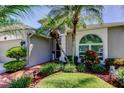 Inviting entrance with tropical landscaping and a well-manicured lawn at 14427 Pepperpine Dr, Tampa, FL 33626