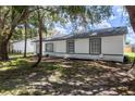 Home exterior with trees, fresh exterior paint, and landscaping at 22716 Penny Loop, Land O Lakes, FL 34639
