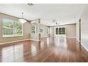 Bright, open-concept living room featuring hardwood floors, lots of natural light, and elegant chandelier at 2544 Rosehaven Dr, Wesley Chapel, FL 33544