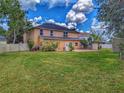 Wide backyard with white fence, stone paver patio, and mature trees at 29916 Cedar Waxwing Dr, Wesley Chapel, FL 33545