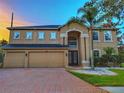 Two-story home boasting a three-car garage and manicured landscaping at 29916 Cedar Waxwing Dr, Wesley Chapel, FL 33545