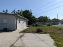 View of the home's rear exterior and backyard featuring a concrete patio area and lush greenery at 4802 Drift Tide Dr, New Port Richey, FL 34652