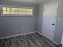 A well-lit room featuring fresh paint, modern flooring, and a unique glass block window detail at 4802 Drift Tide Dr, New Port Richey, FL 34652