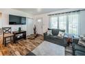 Cozy living room with wood-look floors, gray sofas, and bright natural light streaming through the window at 509 N Washington Ave, Clearwater, FL 33755