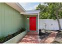 Inviting red front door framed by brick path, greenery, and fresh landscaping at 607 E River Dr, Temple Terrace, FL 33617