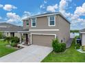 Inviting two-story home features a well-kept lawn, lush landscaping and a two-car garage at 636 Olive Conch St, Ruskin, FL 33570