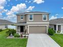 Charming two-story home with a two-car garage, green lawn and lovely landscaping at 636 Olive Conch St, Ruskin, FL 33570