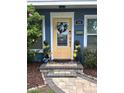Inviting front door with decorative wreath, elegant stonework, and neat landscaping enhances curb appeal at 906 Ponce De Leon Blvd, Belleair, FL 33756