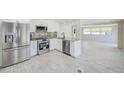 Modern kitchen with stainless steel appliances and granite countertops overlooking the living area at 9790 66Th N St # 37, Pinellas Park, FL 33782